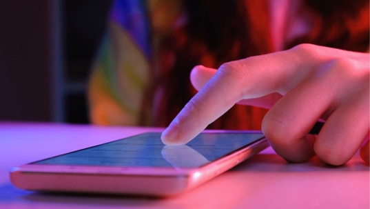 Hands of Girl scrolling up photos at smartphone